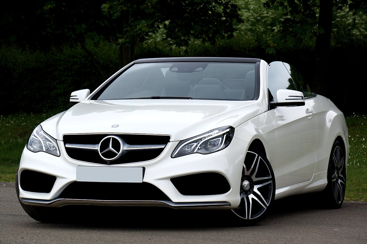 White Mercedes-Benz convertible car parked outdoors showcasing luxury and style.