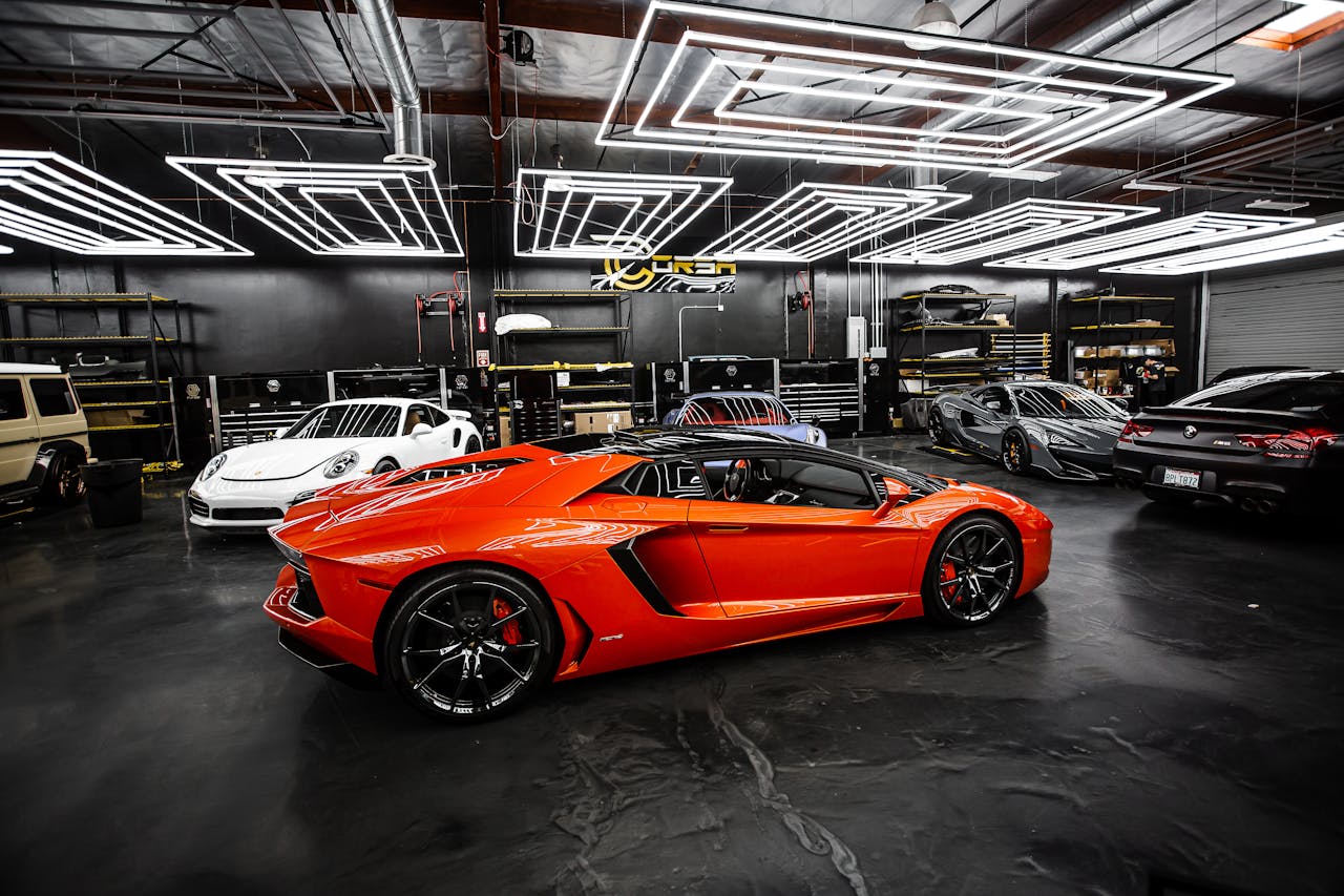 High-end sports cars displayed in a sleek, modern showroom with stylish lighting.
